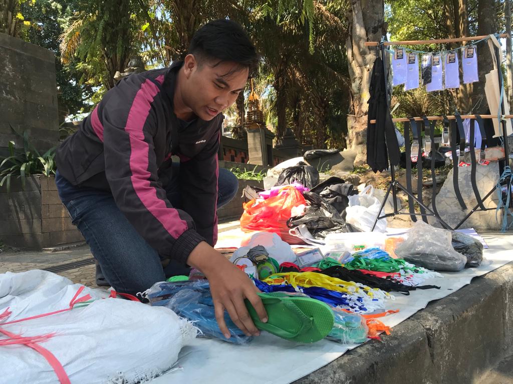 MUSIMAN: Penjual perlengkapan ospek mahasiswa baru menata barang dagangannya di jalur pedestrian Jalan Veteran, Lowokwaru, kemarin siang.  (Fajar Andre/Radar Malang)