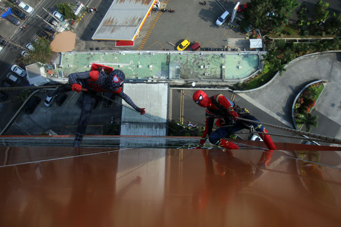 SEJAK 2016: Dua pekerja yang menggunakan kostum Spiderman membersihkan kaca bagian luar Hotel Aria Gajayana, kemarin.