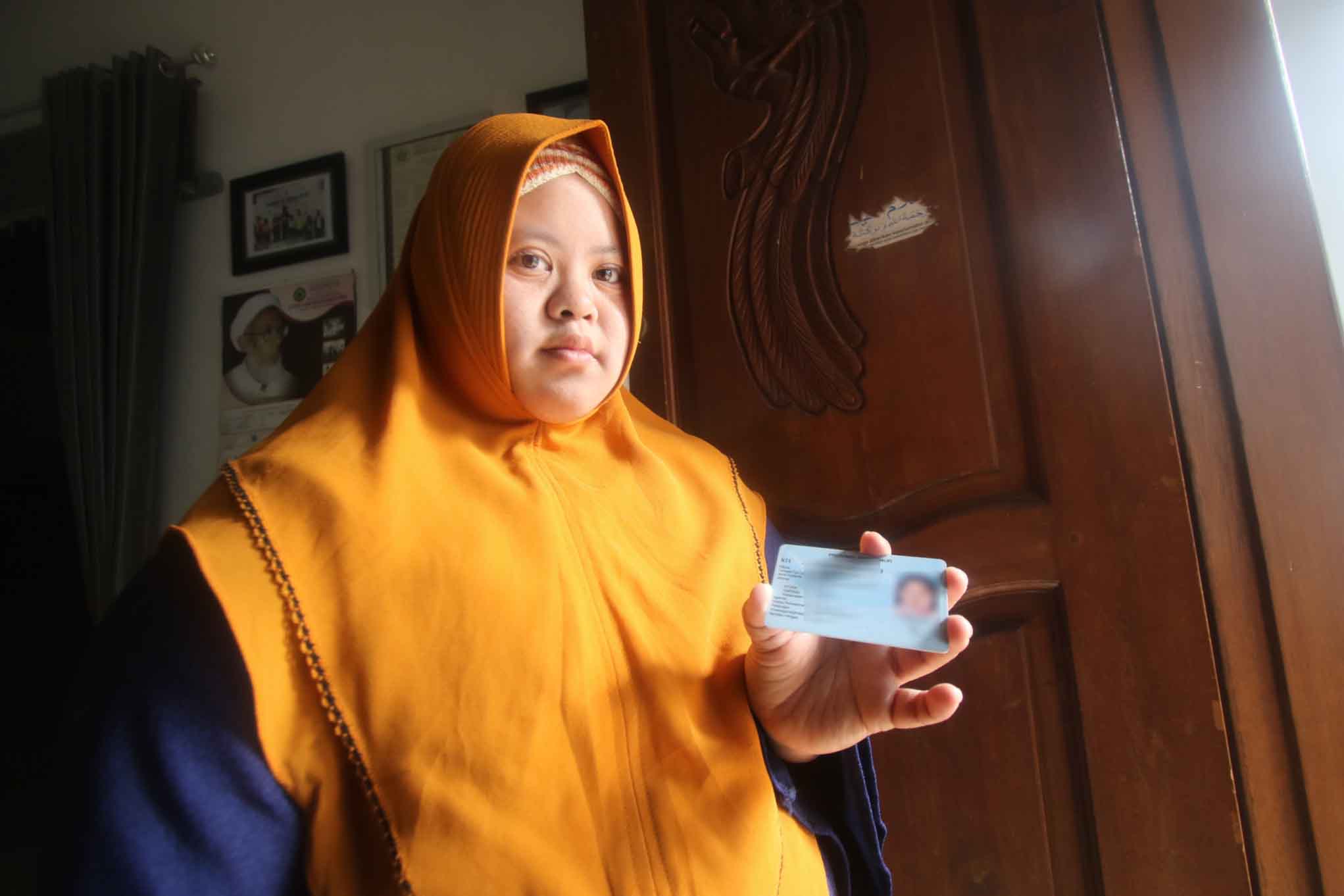 TELAH TERDAFTAR: Seorang penyandang disabilitas menunjukkan E-KTP miliknya yang sudah dicetak dispendukcapil. (Darmono/Radar Malang)