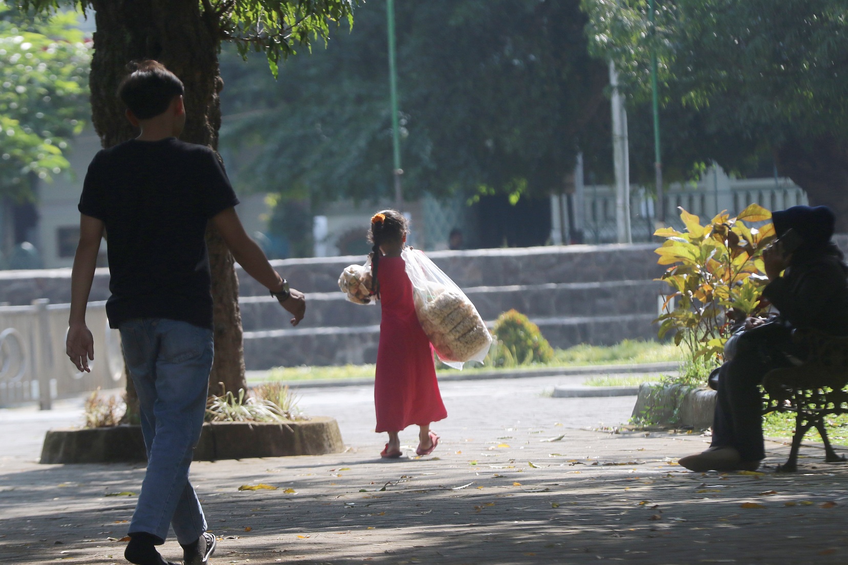 BELUM WAKTUNYA: Seorang anak di bawah umur menjual jajanan ringan di Alun-Alun Merdeka, kemarin. (Darmono/Radar Malang)