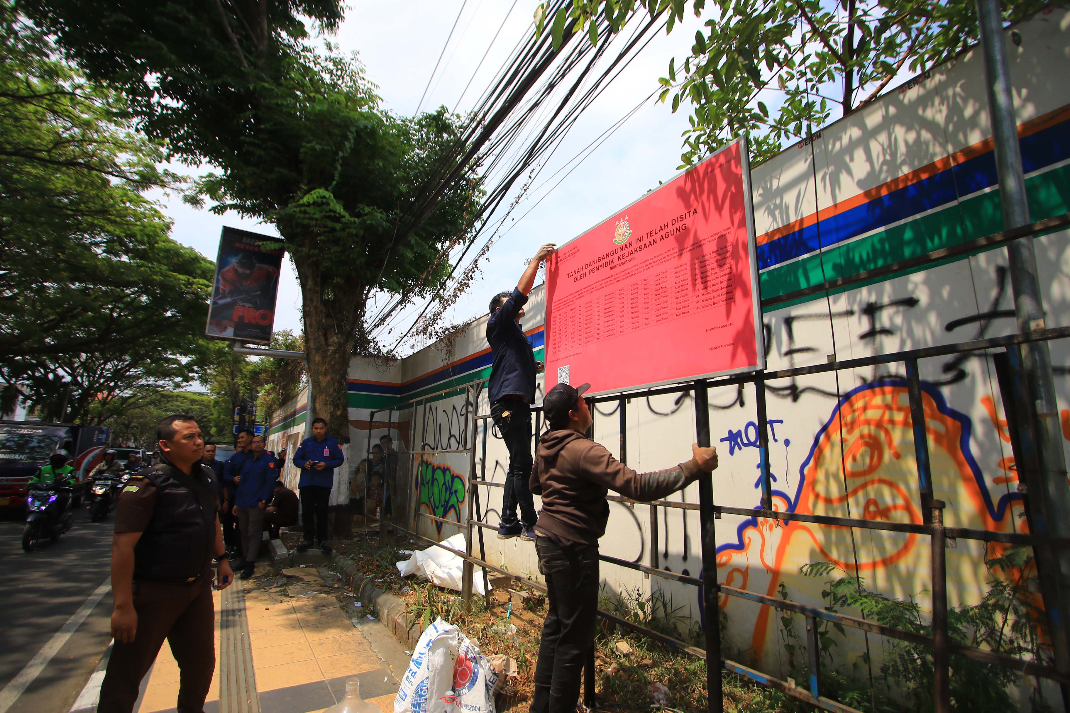 BB KASUS KORUPSI: Petugas memasang pengumuman bahwa tanah dan bangunan Nayumi Sam Tower di Jalan Soekarno Hatta telah disita oleh penyidik Kejaksaan Agung kemarin (7/9).