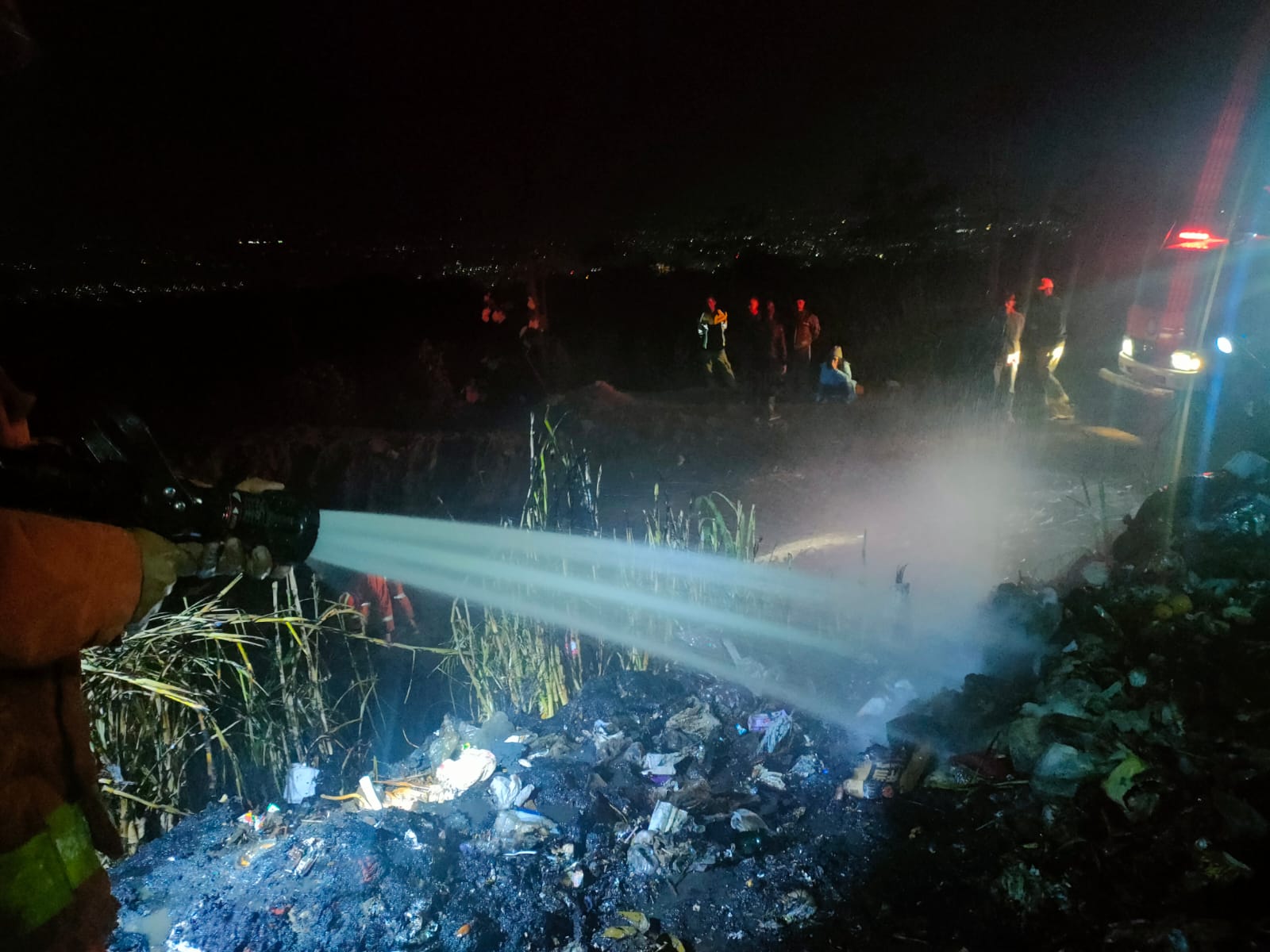 PADAMKAN API: Petugas Damkar Kota Batu menyemprotkan air untuk memadamkan api di TPS3R Oro-Oro Ombo.