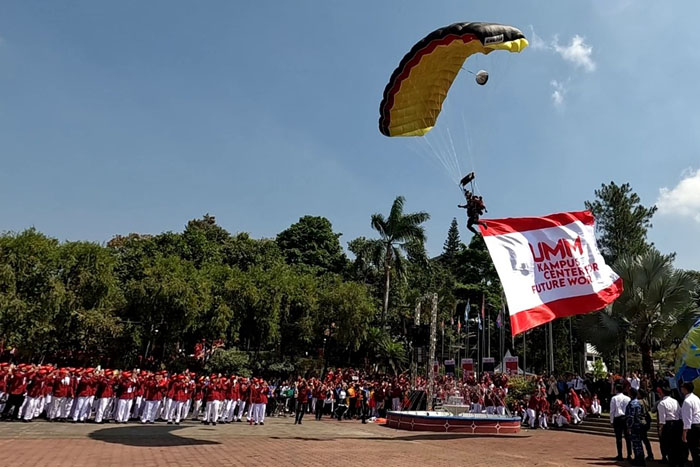 : Salah satu penerjun Polri sukses mendarat di helipad UMM dengan mengibarkan bendera Center for Future Work.