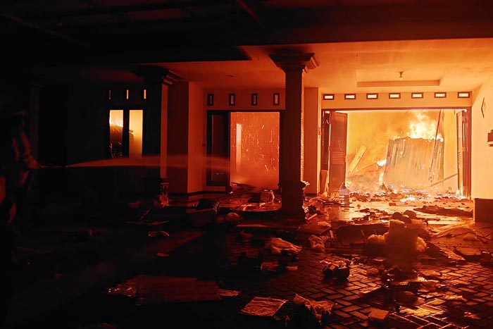 Petugas Damkar Kabupaten Malang menyemprot rumah terbakar berisi mebel dan furniture di Karangsuko Pagelaran.