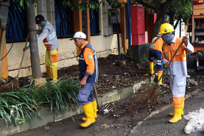Pasukan kuning sedang membersihkan Jalan Jaksa Agung Suprapto Kota Malang.