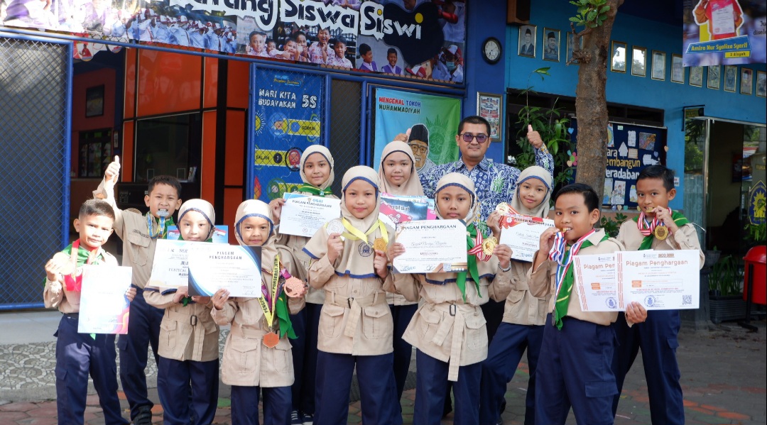 BIKIN BANGGA : Kepala Sekolah Sony Darmawan MPd (tengah) berfoto bersama dengan siswa siswi berprestasi SD Muhammadiyah 9 Malang, beberapa waktu lalu.