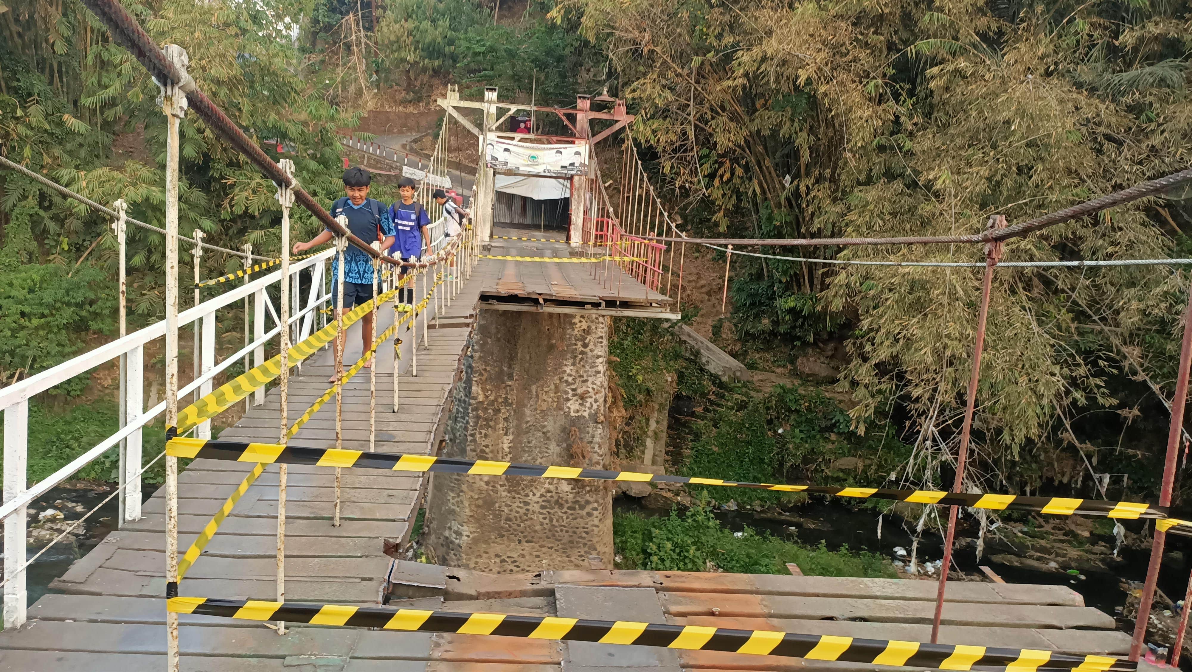 INFRASTRUKTUR: Tiga bocah melintasi jembatan di Jalan Lembayung, Bumiayu yang ditutup sebagian, kemarin (27/9). Rencananya akan ditutup total selama pengerjaan berlangsung