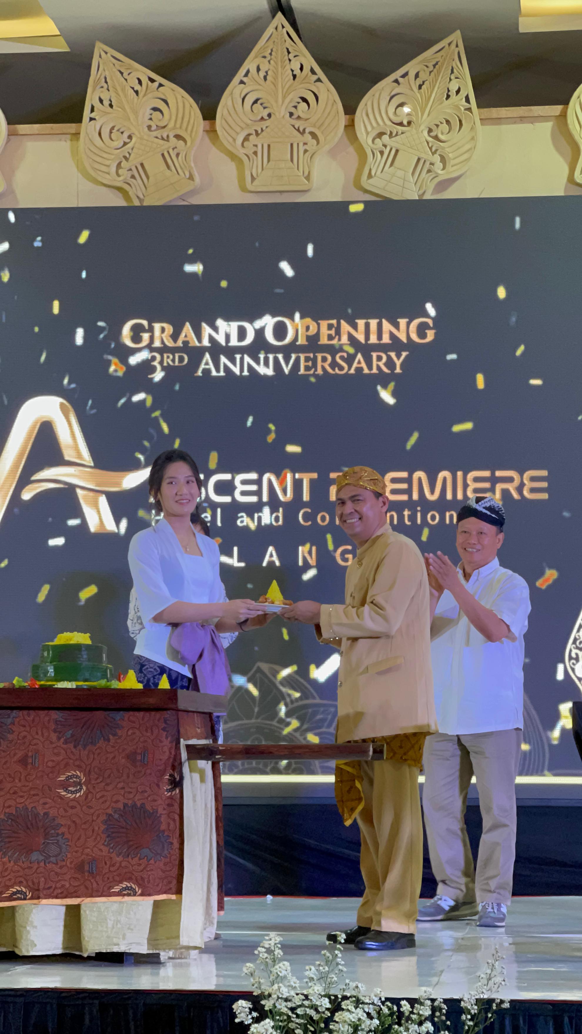RESMI DIBUKA: Direktur Ascent Hospitality Group Melissa Tania (kiri) menyerahkan potongan nasi tumpeng ke GM Ascent Premiere Hotel Indra Muaz, kemarin. (M. Oky Ustman/Radar Malang)
