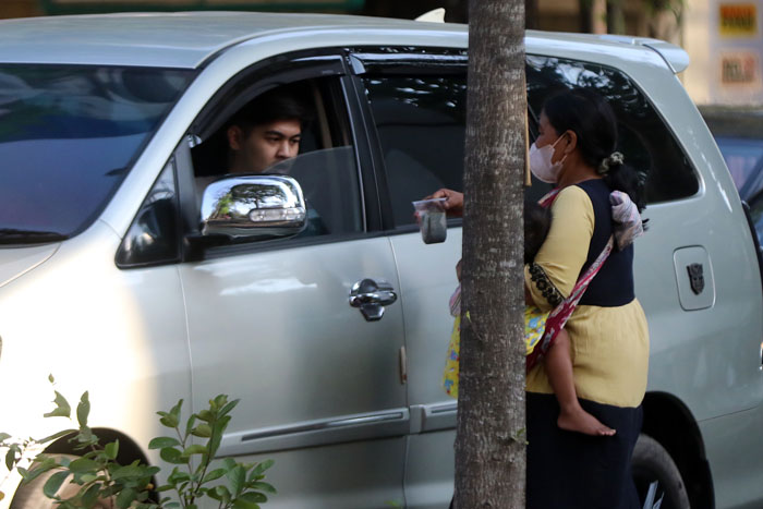 Pengemis perempuan yang membawa anak meminta uang kepada pengendara mobil di Jalan Jaksa Agung Suprapto Kota Malang kemarin (1/10).