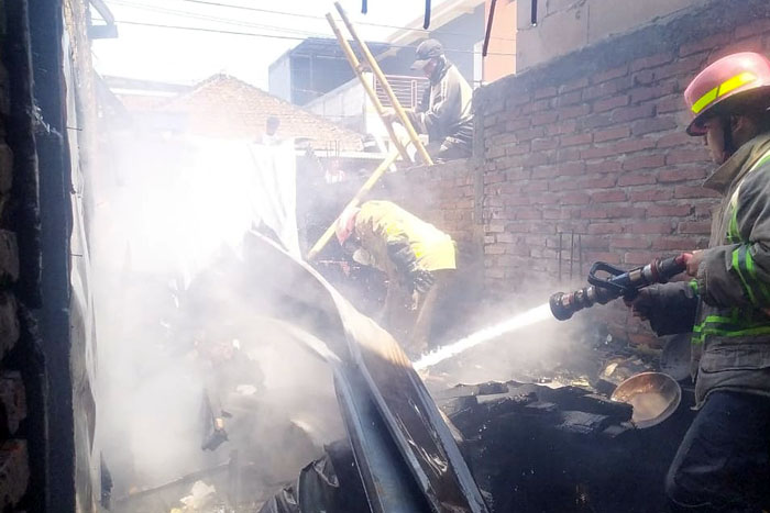 Petugas Damkar Kabupaten Malang berupaya memadamkan api di salah satu rumah warga di Jalan Lettu Benu, Kecamatan Dau kemarin.