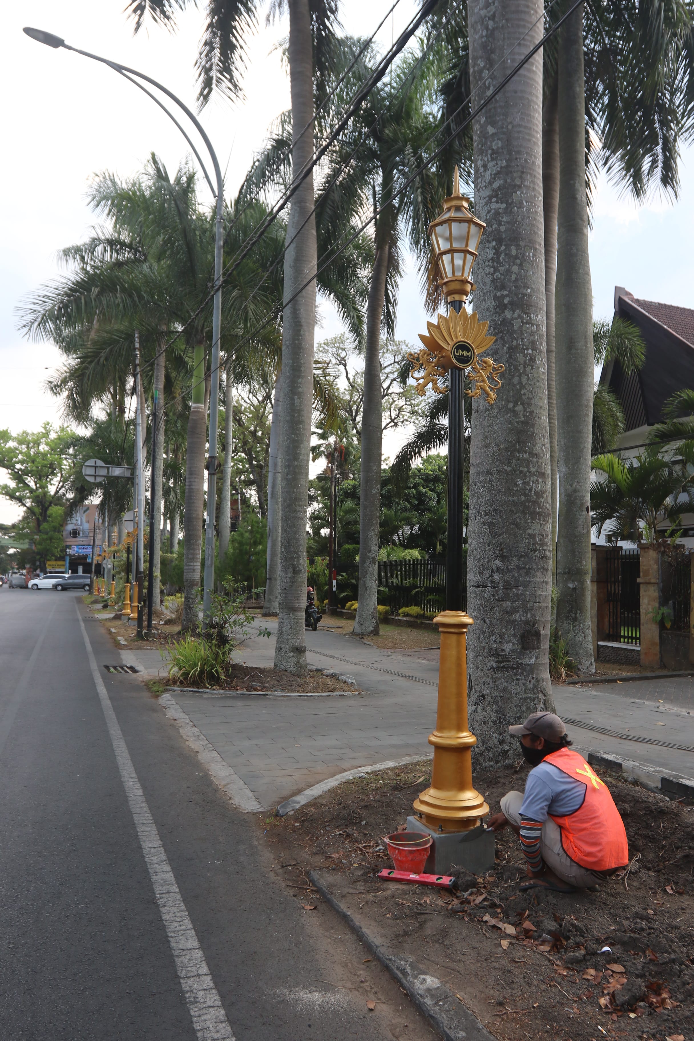 PENERANGAN: Seorang pekerja memasang beton untuk tumpuan tiang lampu hias di Jalan Ijen, Kota Malang, kemarin (6/10).