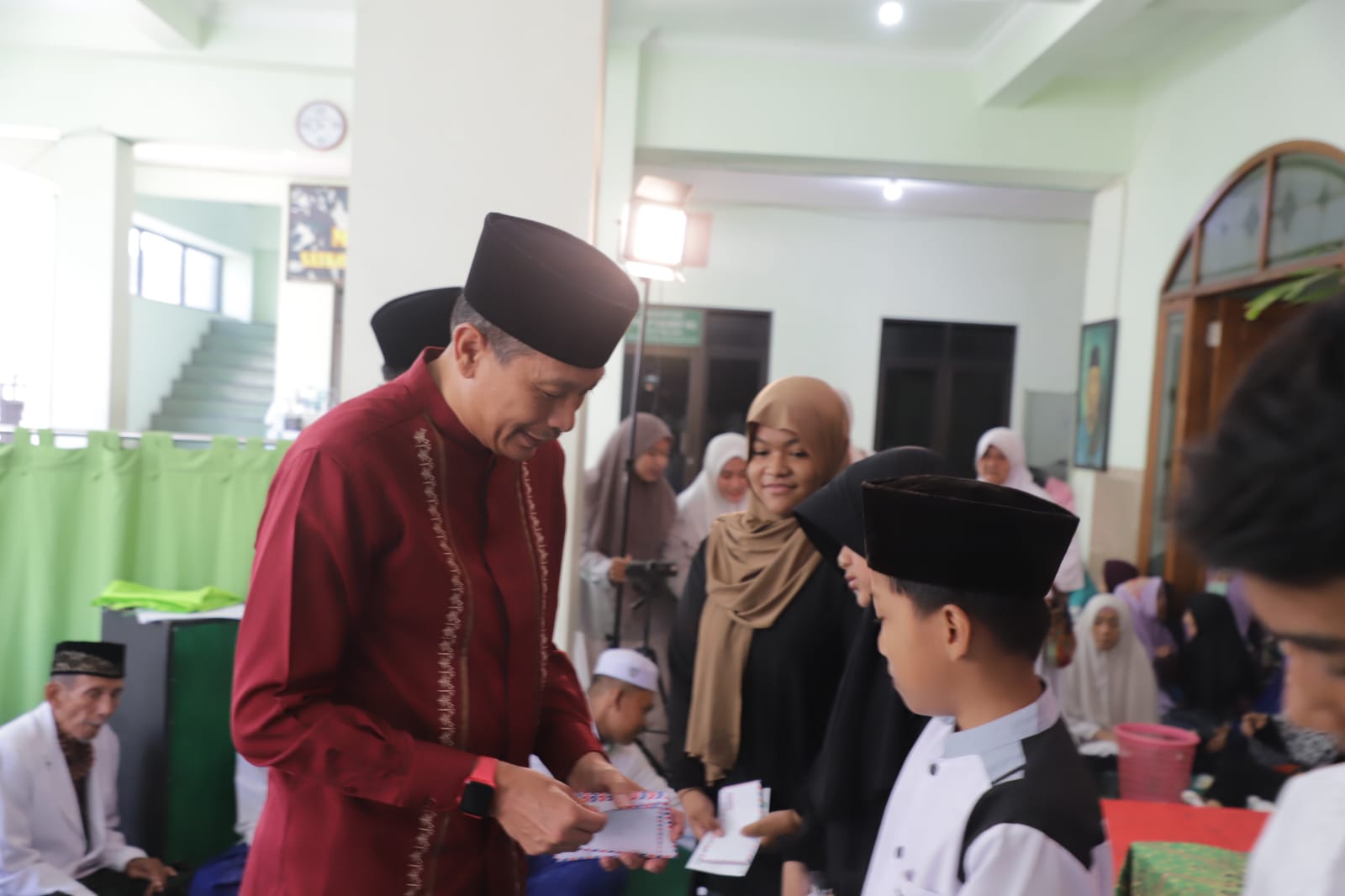 Pj Wali Kota Malang Wahyu Hidayat menyerahkan santunan kepada anak-anak yatim di sela-sela peringatan Maulid Nabi Muhammad SAW, (8/10).