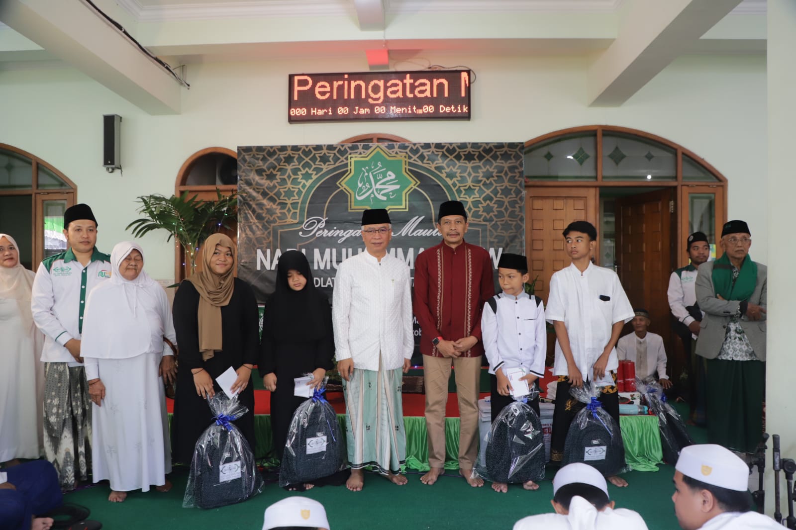 Pj Wali Kota Malang Wahyu Hidayat dan Ketua PCNU Kota Malang KH Isroqunnajah bersama anak-anak yatim dalam peringatan Maulid Nabi di Kantor PCNU Kota Malang, Minggu (8/10)