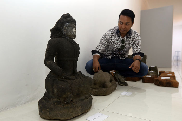 Salah seorang anggota TACB Kota Malang menunjukkan arca yang diekskavasi untuk ditempatkan di Museum Mpu Purwa kemarin (11/10)