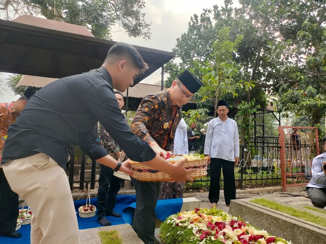 ZIARAH: Pj Wali Kota Batu Aries Agung Paewai menaburkan bunga ke pusaran mantan Wali Kota Batu Imam Kabul, Jumat (13/10).