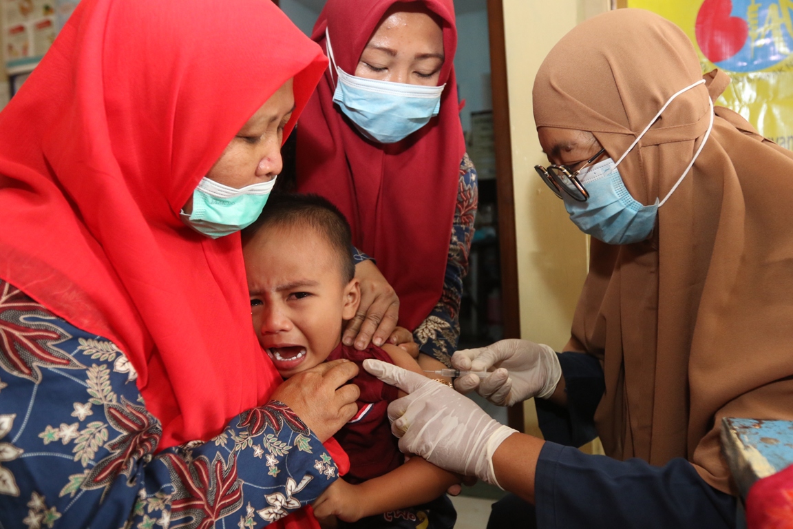 PENTINGNYA IMUNISASI: Petugas memberikan imunisasi kepada bayi di Posyandu di Desa Pakisaji,Kecamatan Pakisaji. Penyakit campak bisa menyerang karena imunisasi tidak lengkap. (Darmono/Radar Malang)  &nbsp;