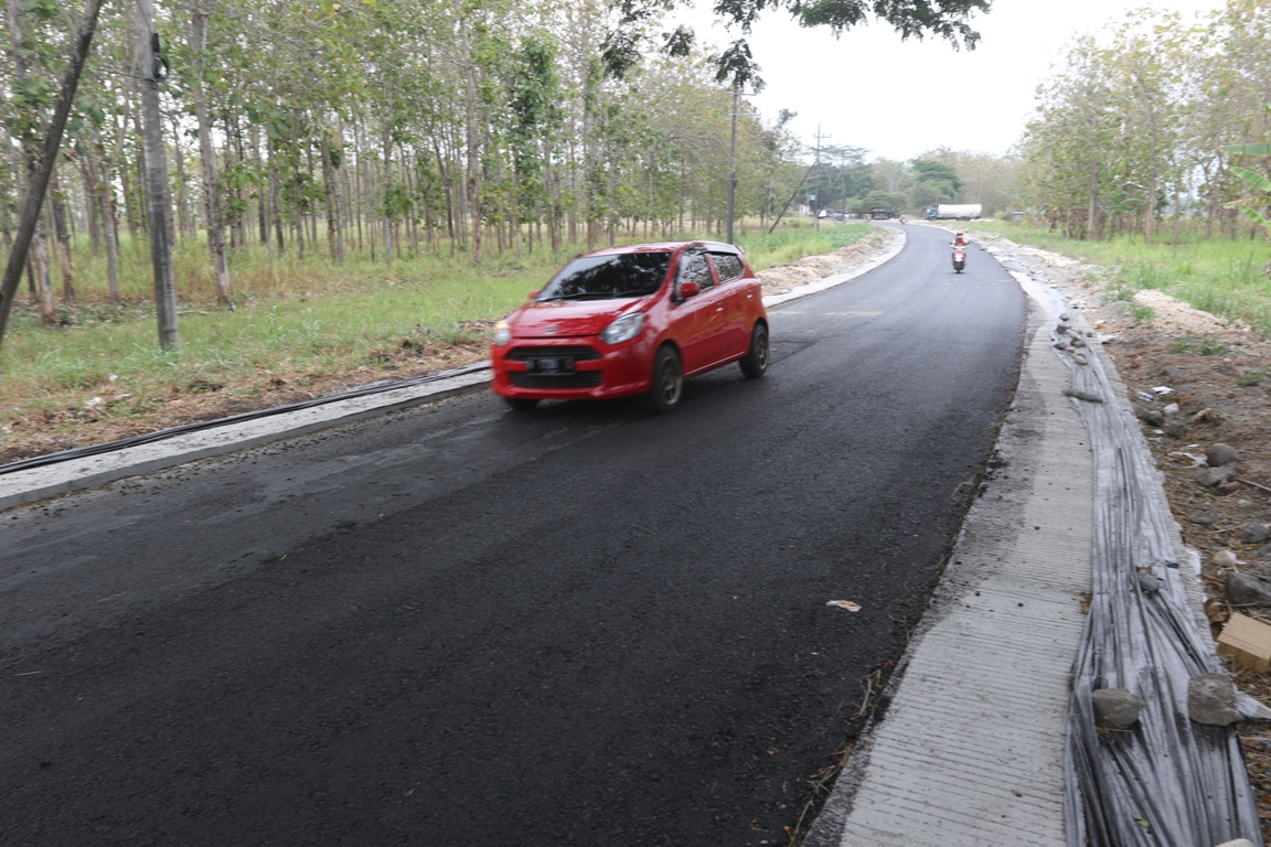 &nbsp;  MAKIN LEBAR: Sejumlah kendaraan melintas di segmen 1 ruas jalan Karangkates-Kalipare yang baru selesai diaspal. (Darmono/Radar Malang)  &nbsp;