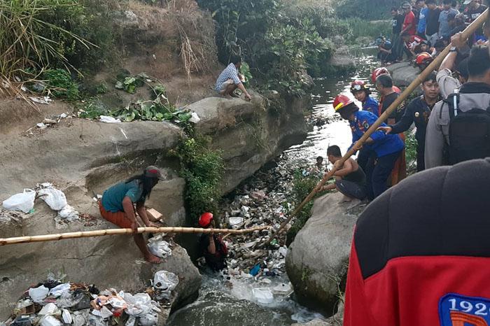 Tim gabungan melakukan pencarian korban di Sungai Brantas kemarin (19/10). Tumpukan sampah sempat menghambat petugas.