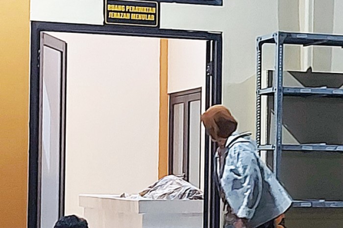 Jenazah Agus Tomy, 45, warga RT 5 RW 7, Kelurahan Buring, Kecamatan Kedungkandang, dibawa ke kamar mayat RSSA Malang, Kamis malam (19/10).