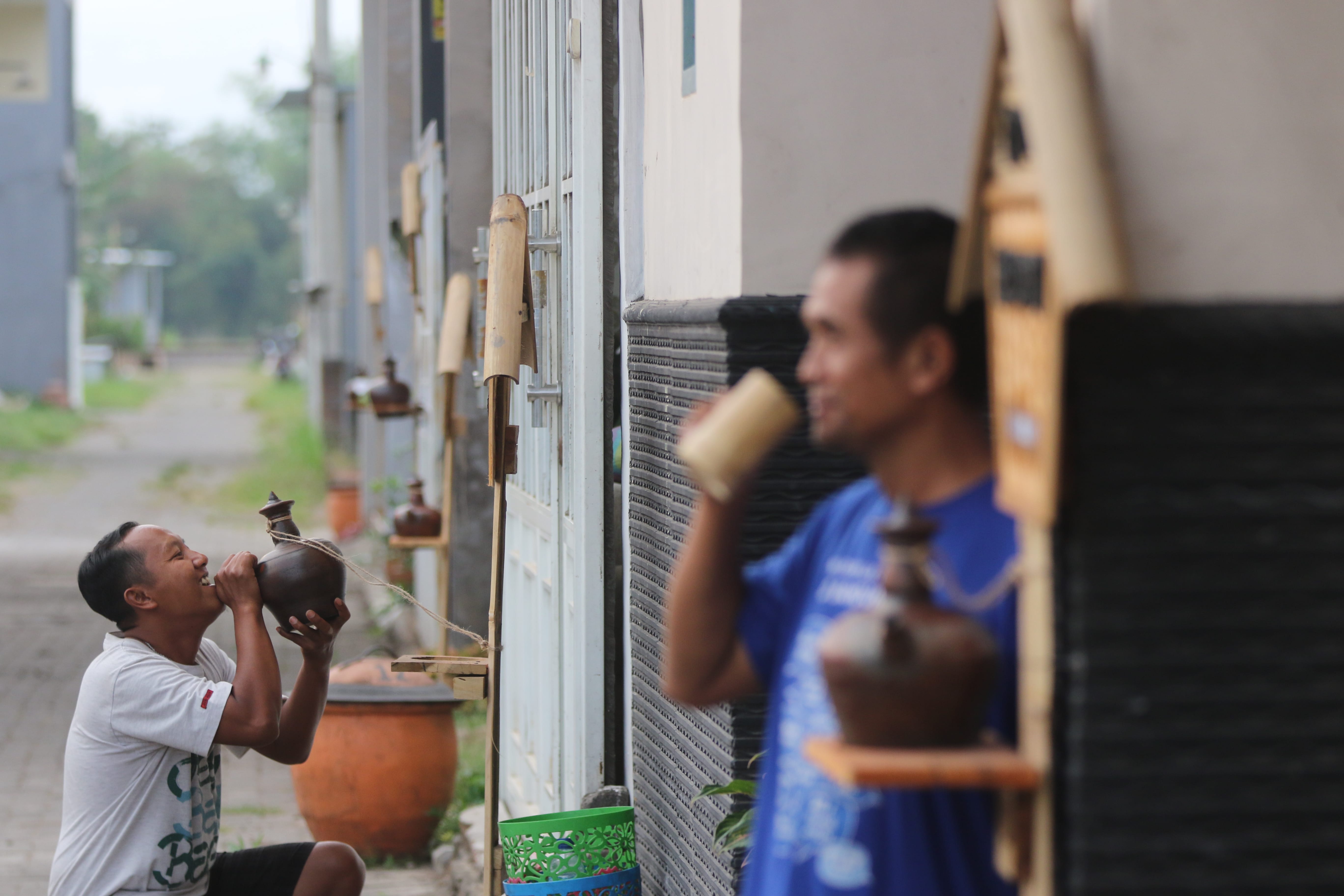 KAMPUNG TEMATIK: Salah seorang warga meminum air dari kendi di RT 08 RW 06 Kelurahan Gadang, Kecamatan Sukun, kemarin (23/10). Mereka menyuguhkan suasana kuno untuk melestarikan budaya lokal.