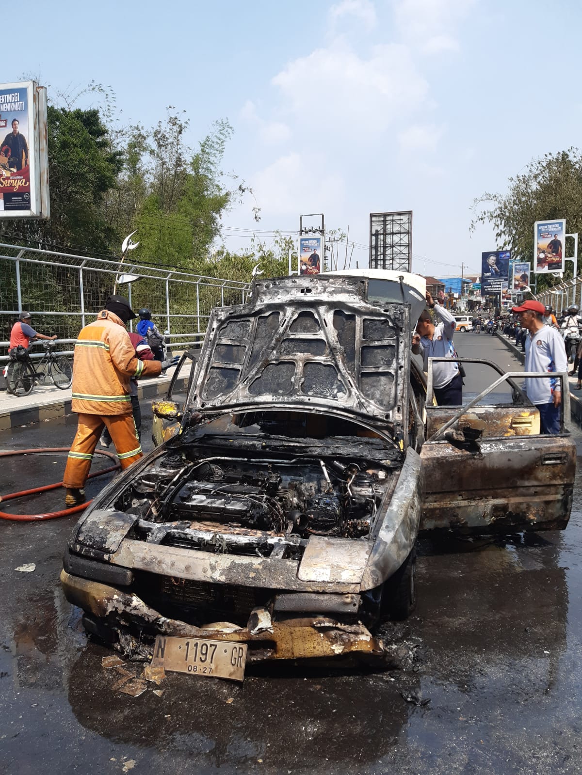 LAKA LANTAS: Personel Damkar Kota Malang memadamkan kobaran api yang menghanguskan mobil Mazda Astina di Jalan Ranugrati kemarin (27/10)