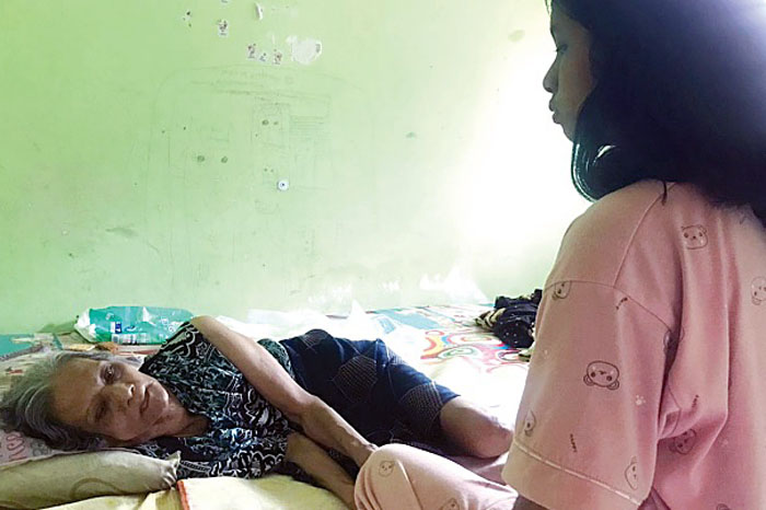 PUTUS SEKOLAH: Meliani Arum Dewantari memandangi neneknya yang terbaring lemas di tempat tidur rumahnya kemarin (26/10)