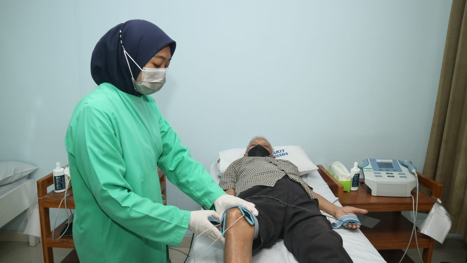 Petugas rehab medis RSPH memasangkan alat pada kaki pasien