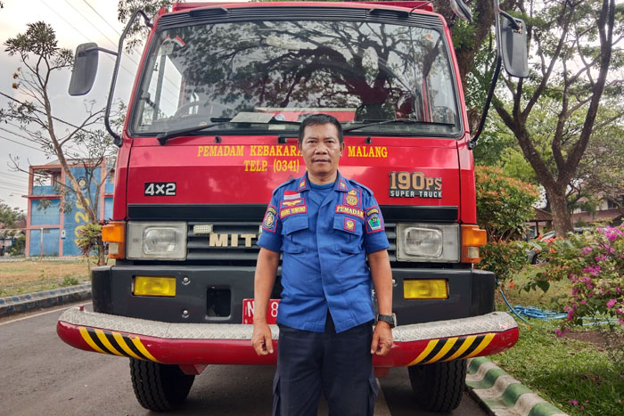 SIAGA: Anang Yuwono berada di depan mobil Damkar Kota Malang, Jalan Bingkil, Kelurahan Ciptomulyo, Kecamatan Sukun, kemarin (30/10)
