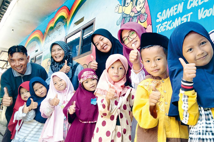 Pasutri M Noor Choirullah dan Abyz Wigati (paling kiri) bersama tujuh anak prasekolah dan dua staf pengajar foto bersama di depan kantor LKSA Harapan Ummat, Lowokwaru, Kota Malang.