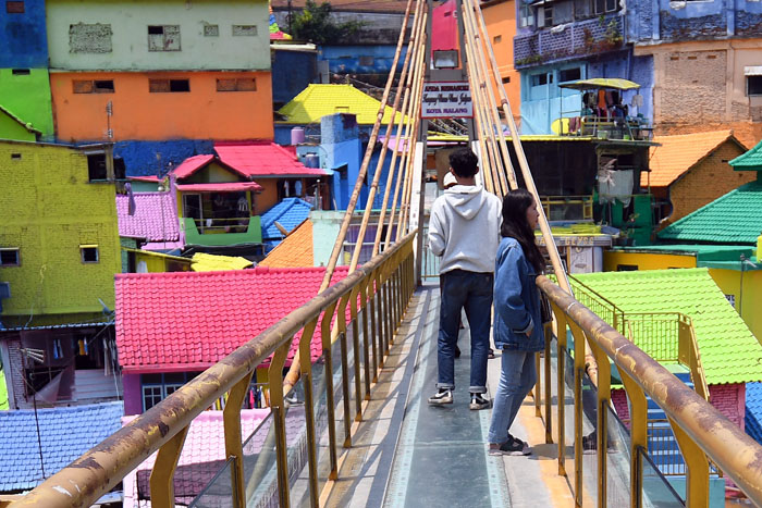 JADI PERHATIAN NASIONAL: Wisatawan menikmati keindahan kampung warna-warni dari jembatan kaca kemarin (1/11).