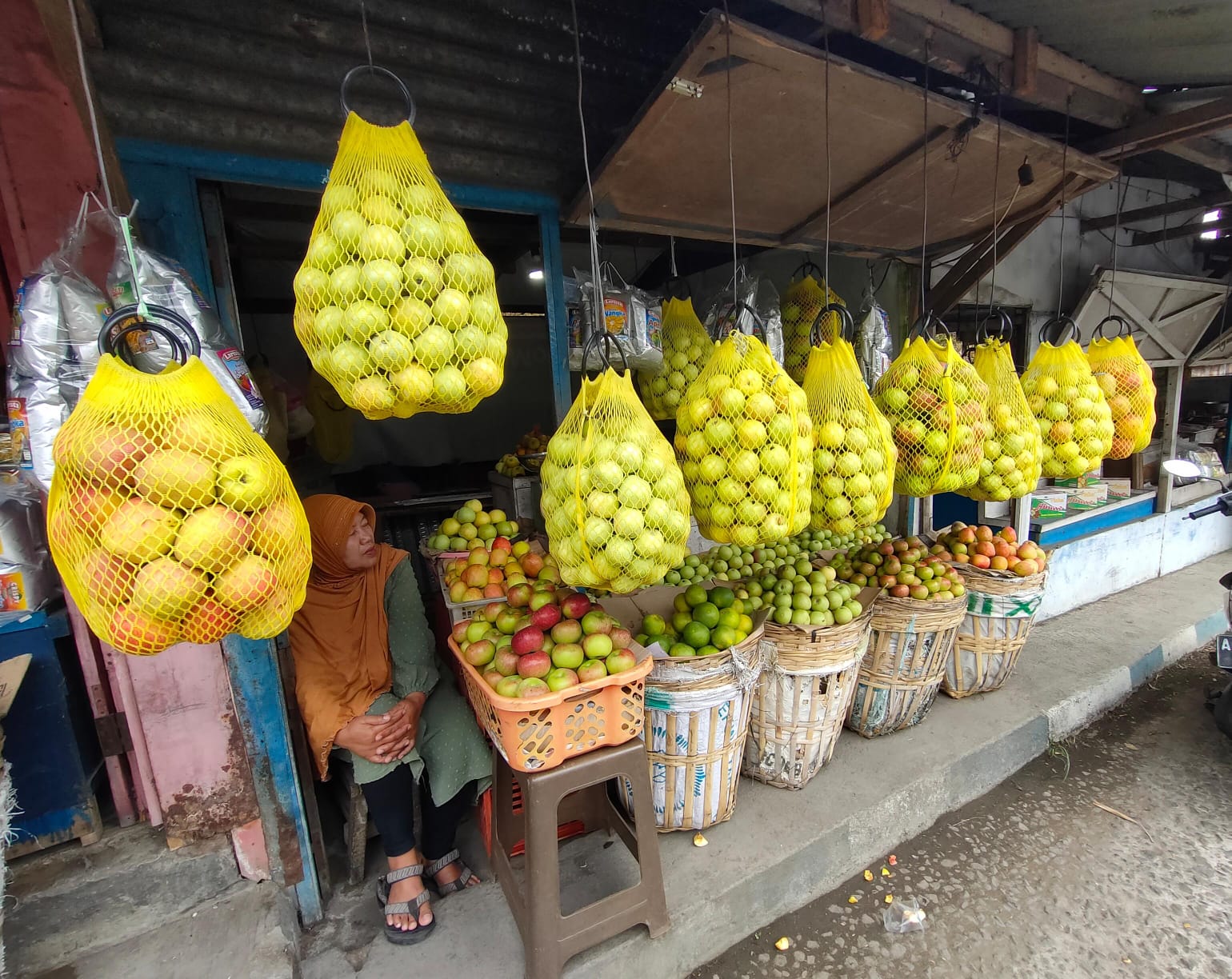 SEPI: Salah satu pedagang apel di Bumiaji sedang menunggu pembeli yang kian menurun.