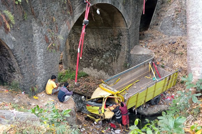 PENGEMUDI SELAMAT: Truk bernopol N 8931 UY masih berada di bawah jembatan Desa Pamotan, Kecamatan Dampit kemarin siang. Truk itu baru bisa dievakuasi sekitar pukul 17.00.