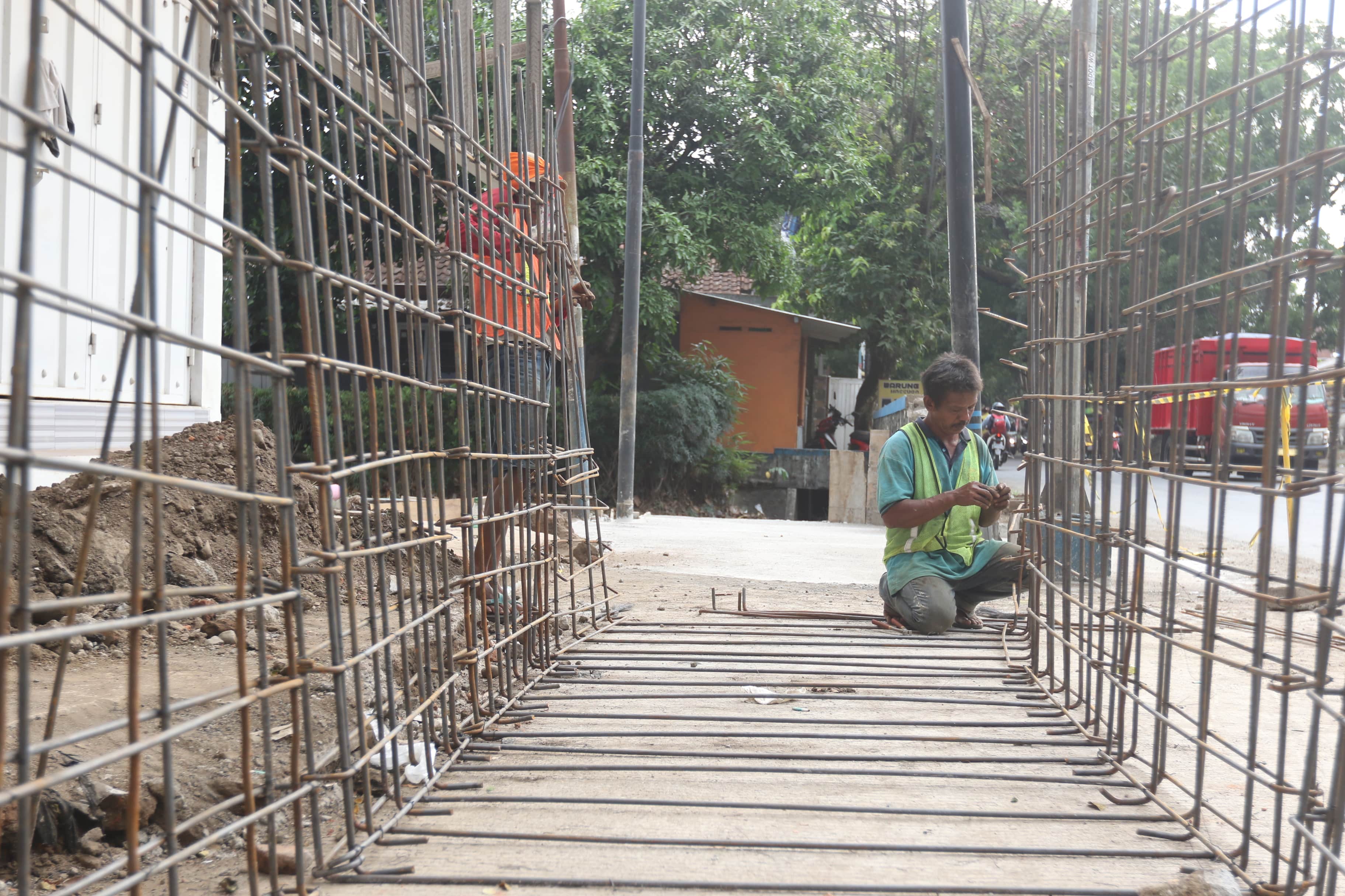 INFRASTRUKTUR: Seorang pekerja memasang besi-besi untuk proyek pelebaran jalan di Jalan Ki Ageng Gribig kemarin (10/11)