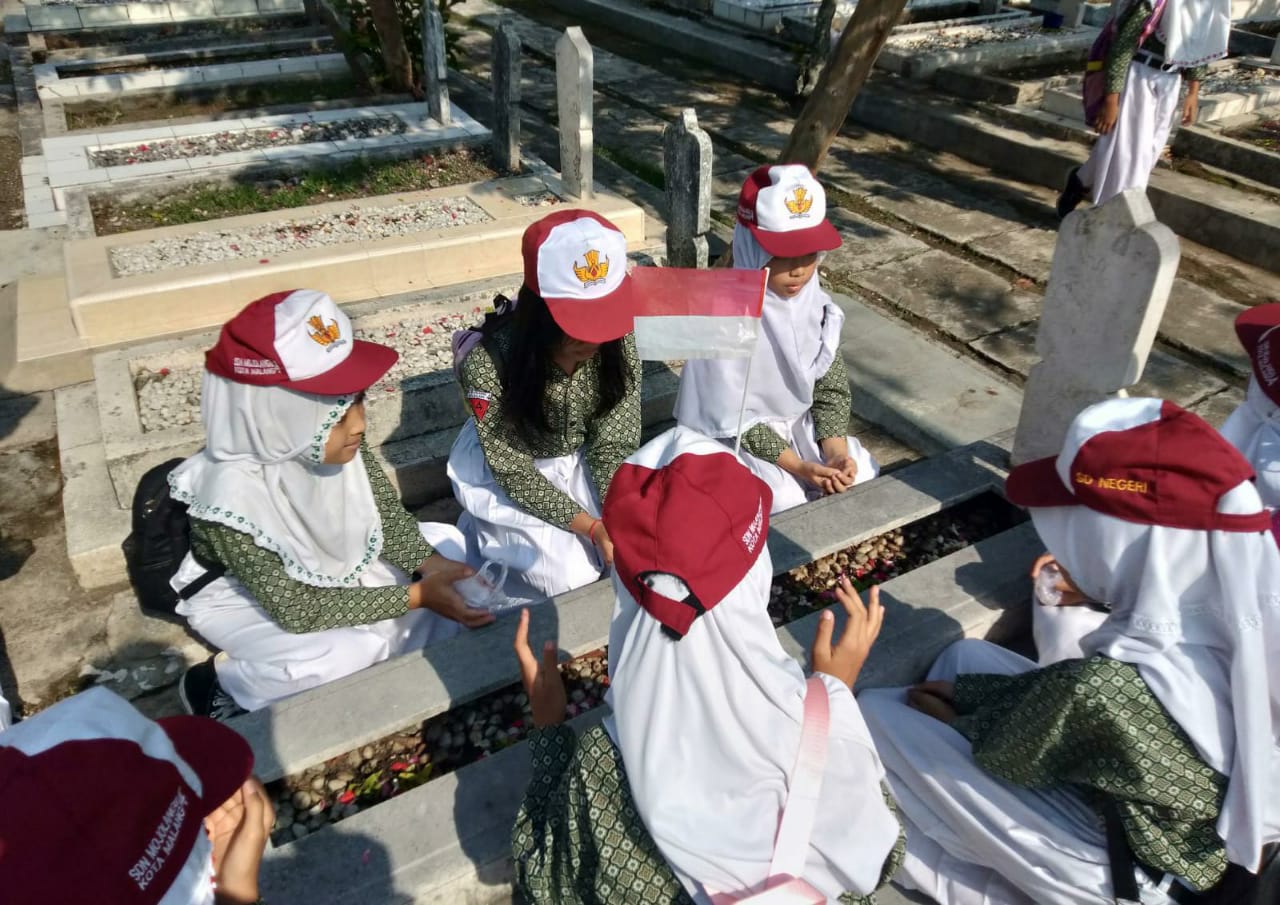 KHUSYUK : Beberapa siswi SDN Mojolangu 4, berdoa bersama di salah satu makam pahlawan,&nbsp;kemarin.
