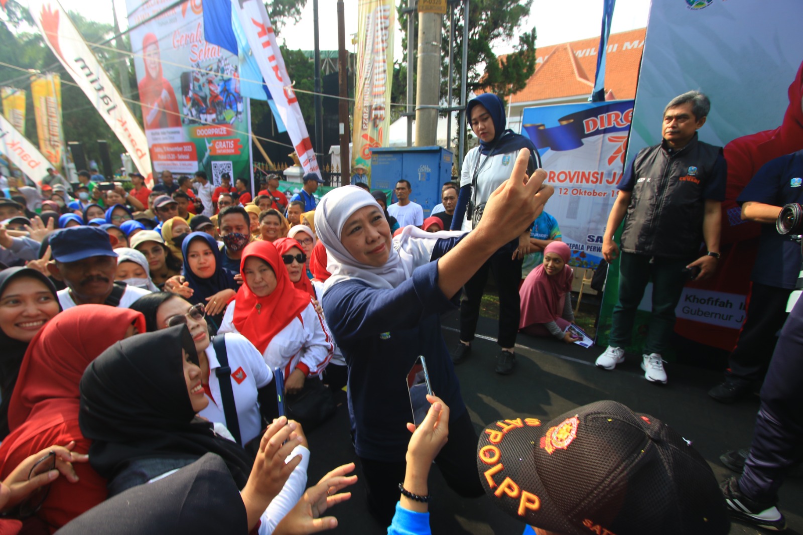 MERIAH: Gubernur Jawa Timur Khofifah Indar Parawansa foto bersama dengan para peserta jalan sehat dalam rangka Peringatan HUT Jatim ke-78 di Bakorwil III Malang pada Minggu (11/11).