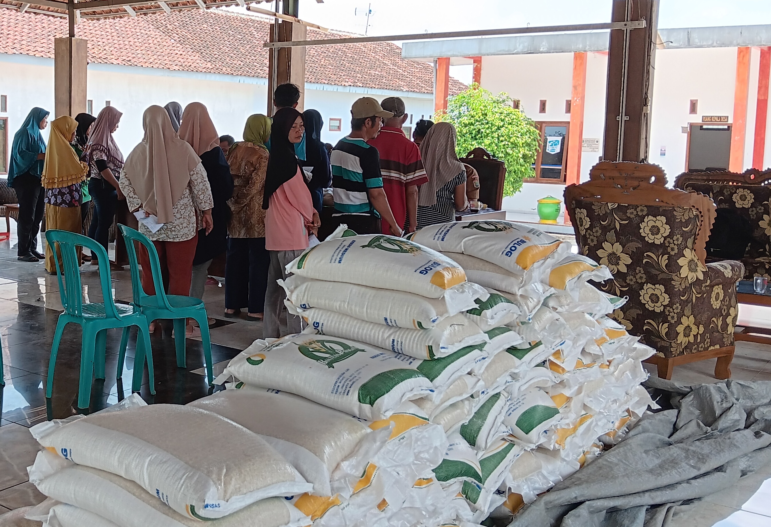 BANTUAN PANGAN: Warga menunggu giliran menerima beras yang dibagikan Kantor Desa Mojosari, Kecamatan Kepanjen kemarin (13/11). (Indah Mei Yunita/Radar Malang)  &nbsp;