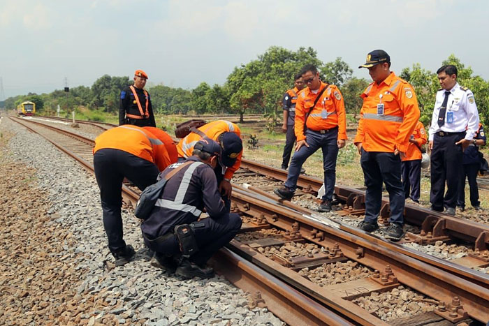 ANALISIS HIDROLIKA: Petugas PT KAI memeriksa kondisi rel kereta api yang berdekatan dengan Kampung Warna-warni kemarin (15/11).