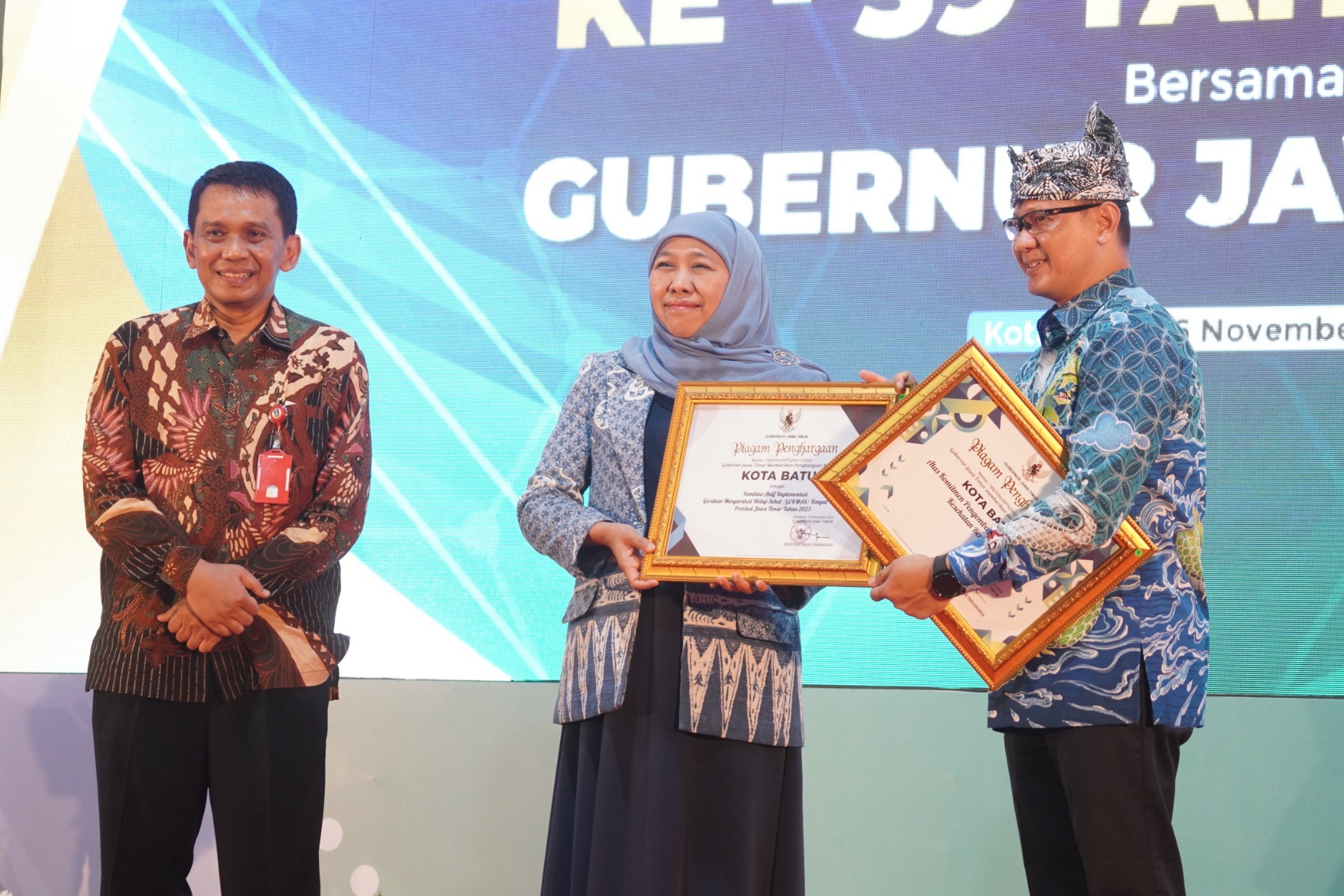 PENYERAHAN: Gubernur Jatim  Khofifah Indar Parawansa menyerahkan penghargaan kepada Pj Wali Kota Batu Aries Agung Paewai.