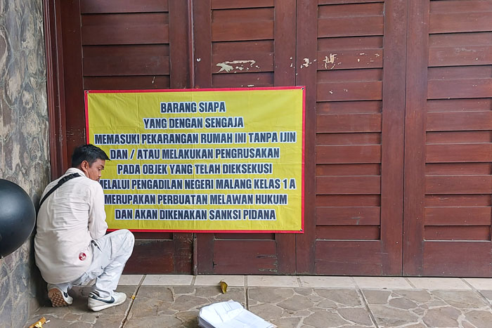 Petugas memasang peringatan agar rumah tersebut dan pekarangannya tidak dimasuki siapa pun tanpa izin.
