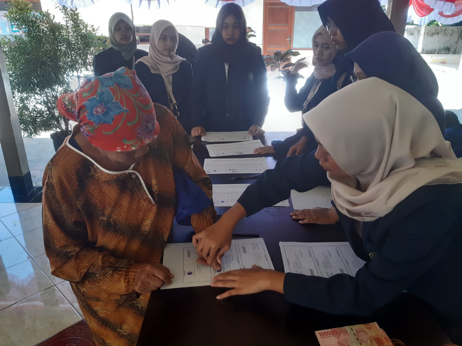 CAP JEMPOL: Petugas membantu salah seorang warga miskin Desa Jenggolo, Kecamatan Kepanjen yang menerima bantuan tunai yang bersumber dari dana desa. (Danang/Radar Malang)