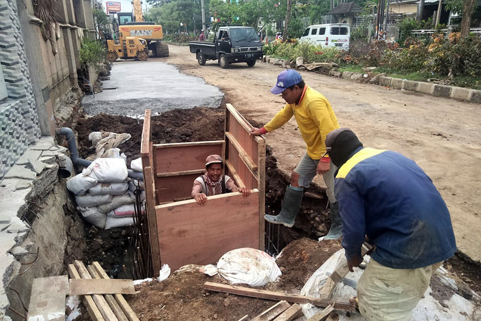 BERPACU DENGAN HUJAN: Proses pengerjaan drainase di Jalan Danau Toba, Kelurahan Sawojajar, masih terus berlangsung hingga kemarin (29/11).