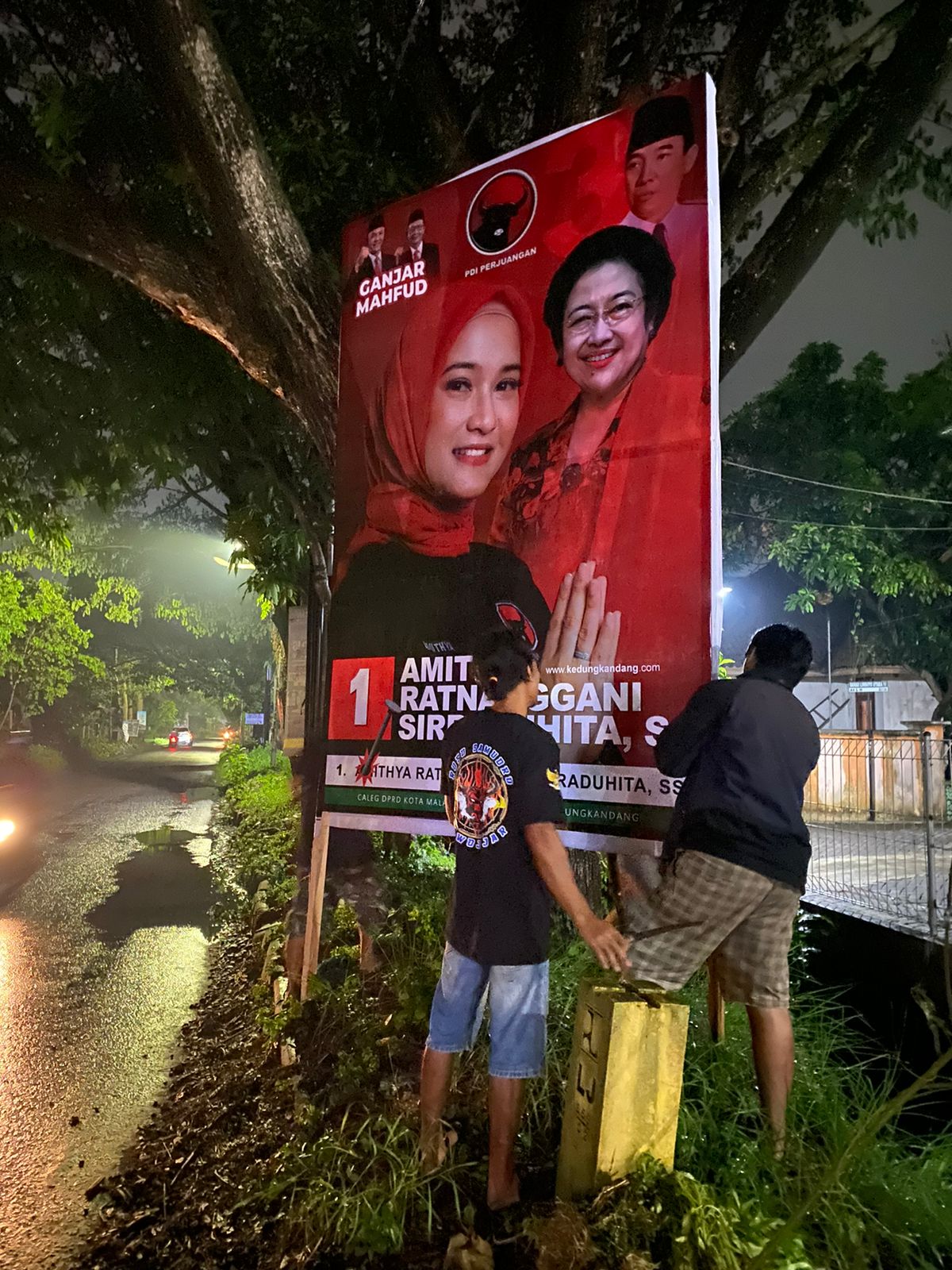 KAMPANYE: Relawan PDIP memasang spanduk caleg yang tersemat foto capres dan cawapres Ganjar-Mahfud di kawasan Kedungkandang akhir November lalu. (Amithya Ratnanggani for Radar Malang)