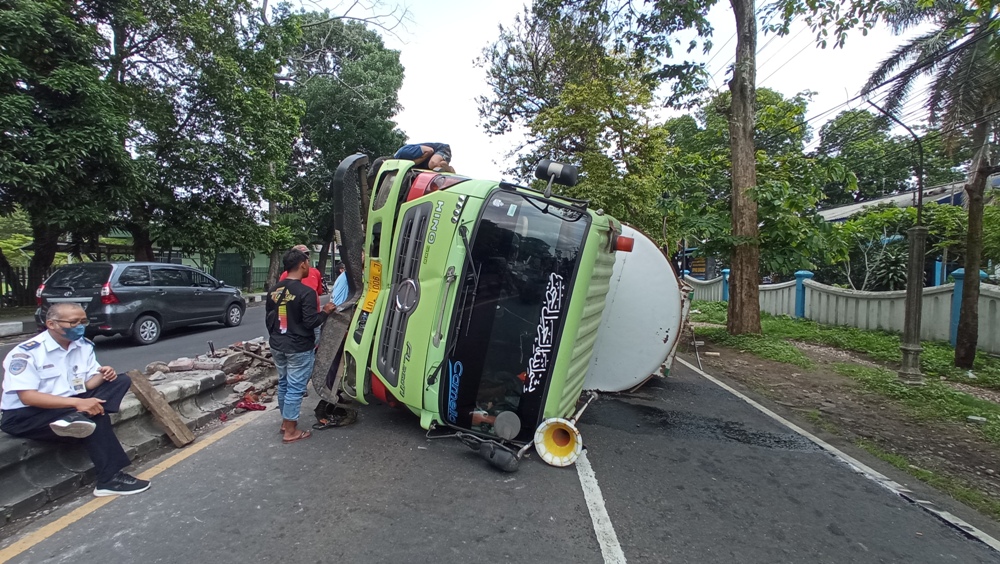 TRUK CELAKA: Kondisi truk tronton tangki yang terguling di Jalan Raya Singosari sebelum dievakuasi dengan menggunakan crane kemarin.