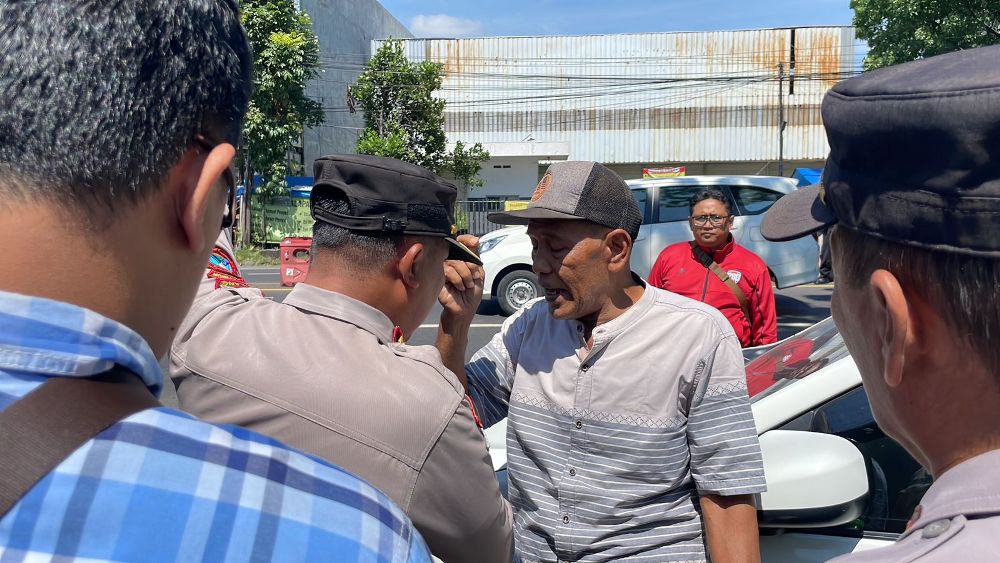 NGEYEL: Petugas berbicara dengan salah seorang pendemo tak berizin di depan kantor Satuan Pelayanan SIM (Satpas) Singosari.