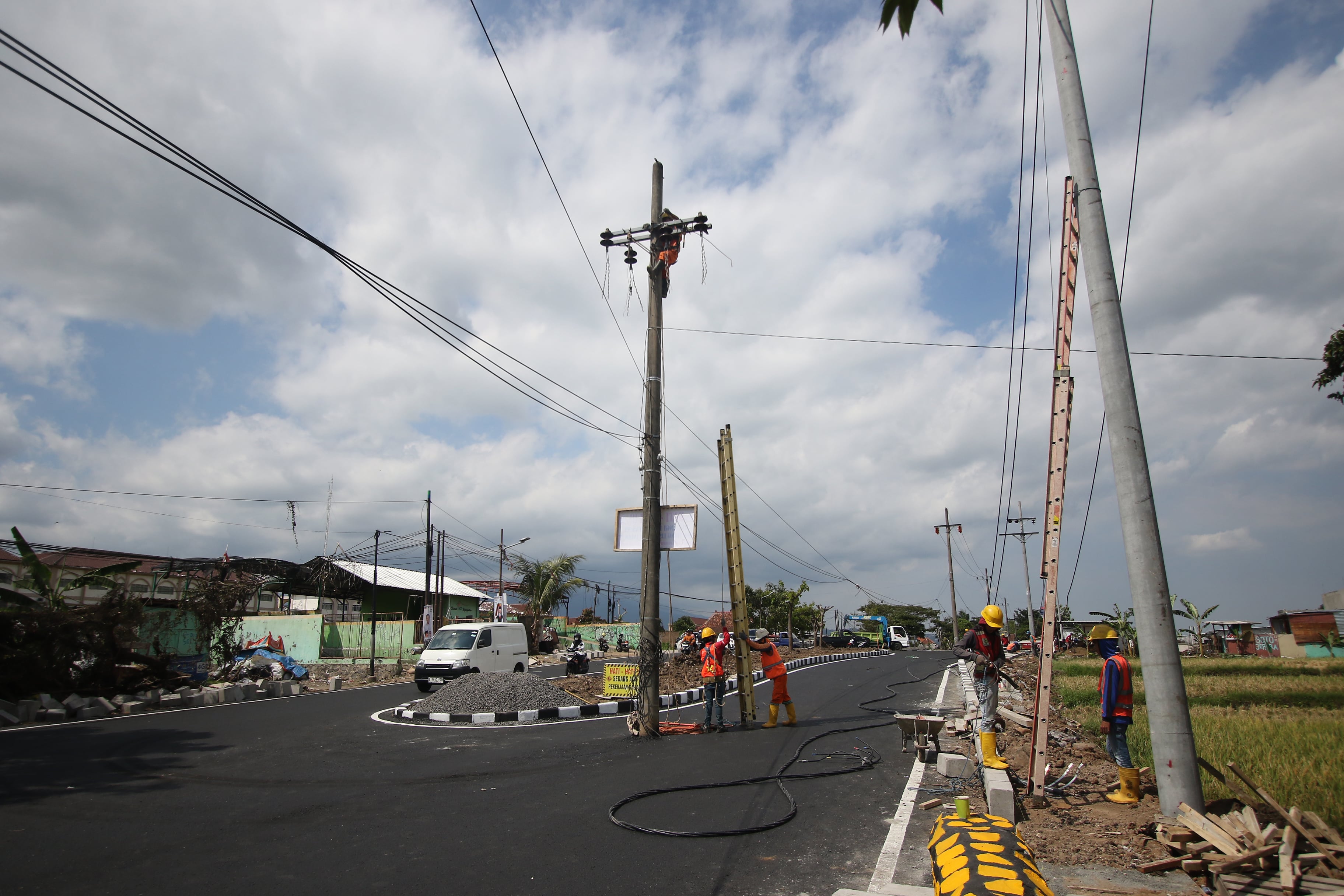 IMBAS PELEBARAN: Beberapa tiang listrik di Jalan Ikan Tombro masih berdiri kemarin. Pembongkaran dilanjutkan hari ini (21/12)