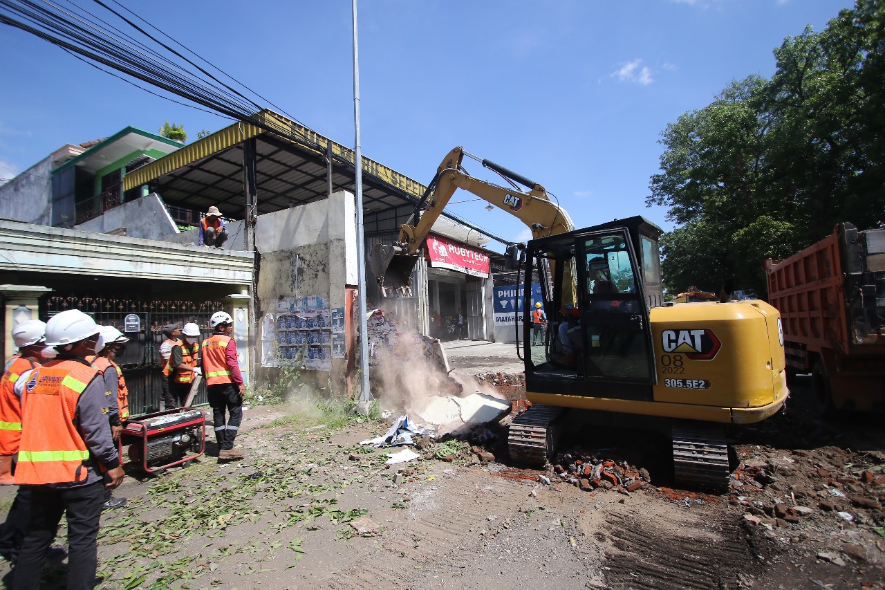 AKHIR PENANTIAN: Pekerja merobohkan tembok bagian depan bekas lahan cucian mobil di dekat gerbang tol Madyopuro kemarin (20/12). Pelebaran ruas Jalan Ki Ageng Gribig pun bisa segera dituntaskan.