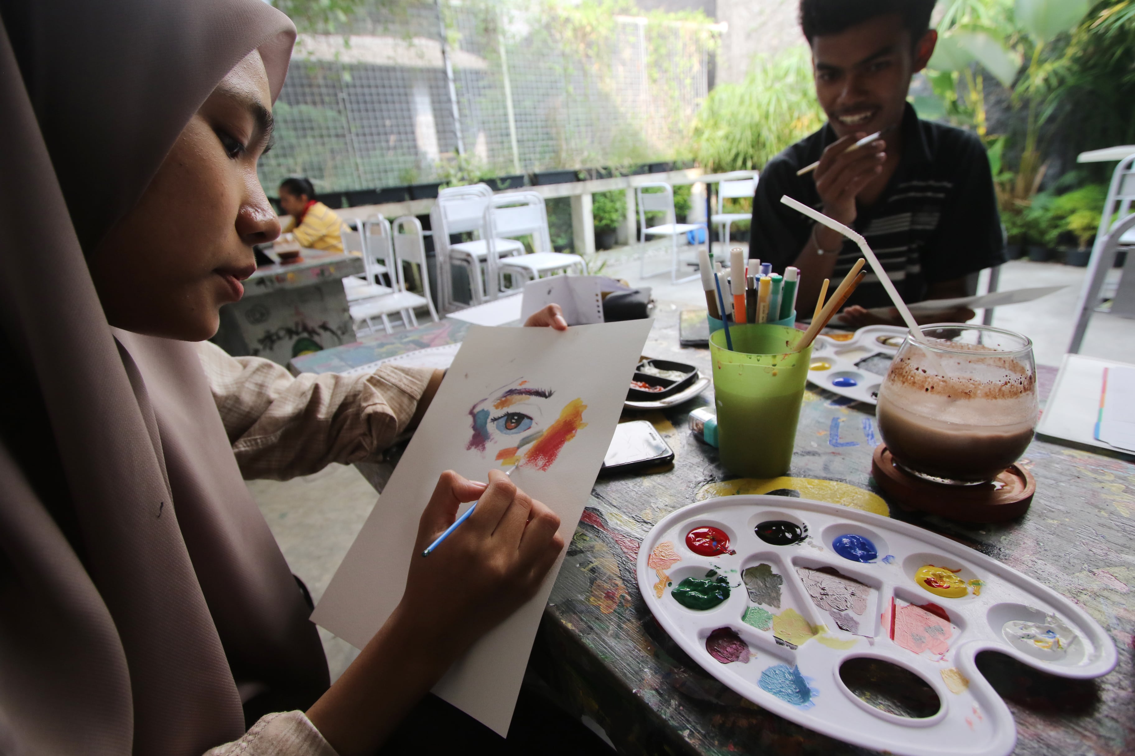 SERIUS: Seorang pengunjung melukis di kertas putih yang tidak terbingkai.