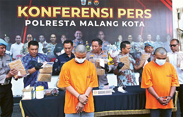 BANYAK BUKTI: Dua tersangka beserta barang bukti ganja dan sabu dihadapkan ke awak media di halaman Polresta Malang Kota, kemarin siang.