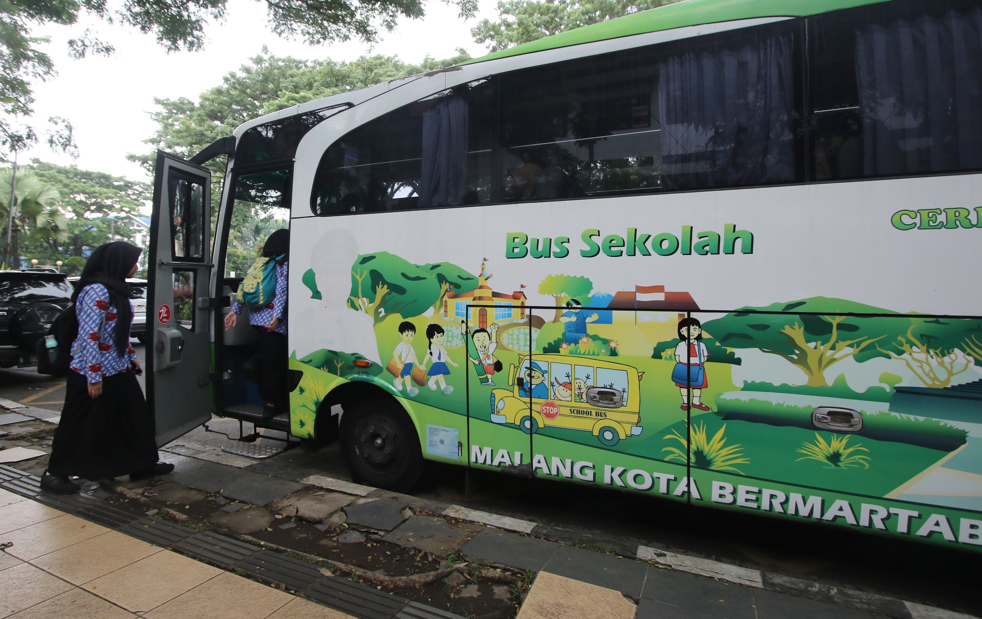 ANTUSIAS: Pelajar SMA di kawasan Tugu antre naik bus sekolah yang terparkir di Jalan Kertanegara kemarin (3/12).