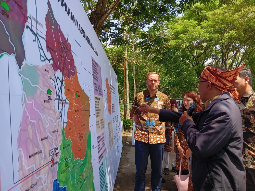 JADI PILOT PROJECT: Vice President Bersih Indonesia AEPW Nicholas Kolesch dan rombongan menyimak penjelasan Kabid Pengelolaan Sampah dan Limbah B3 DLH Kabupaten Malang Renung Rubiyatadji di TPA Paras,